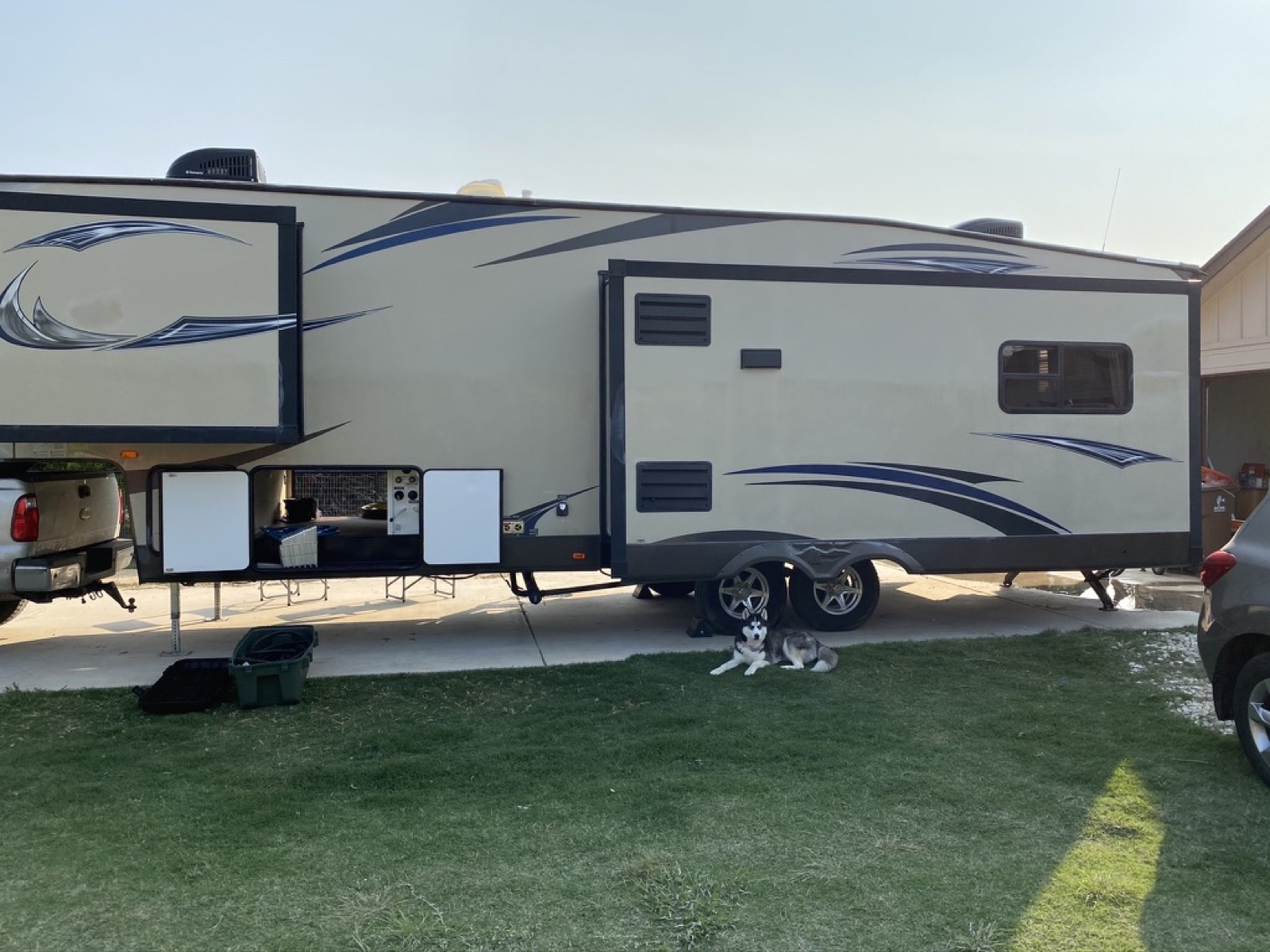 Exterior storage bays open on the fifth wheel — pet-friendly travel ready